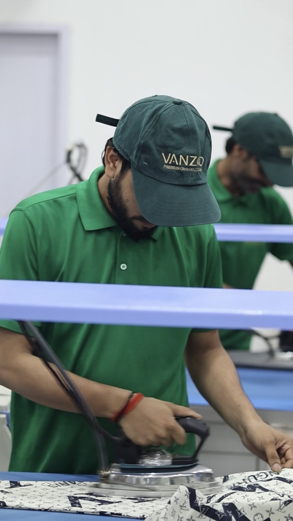Vanzoo team member steam pressing a garment by hand