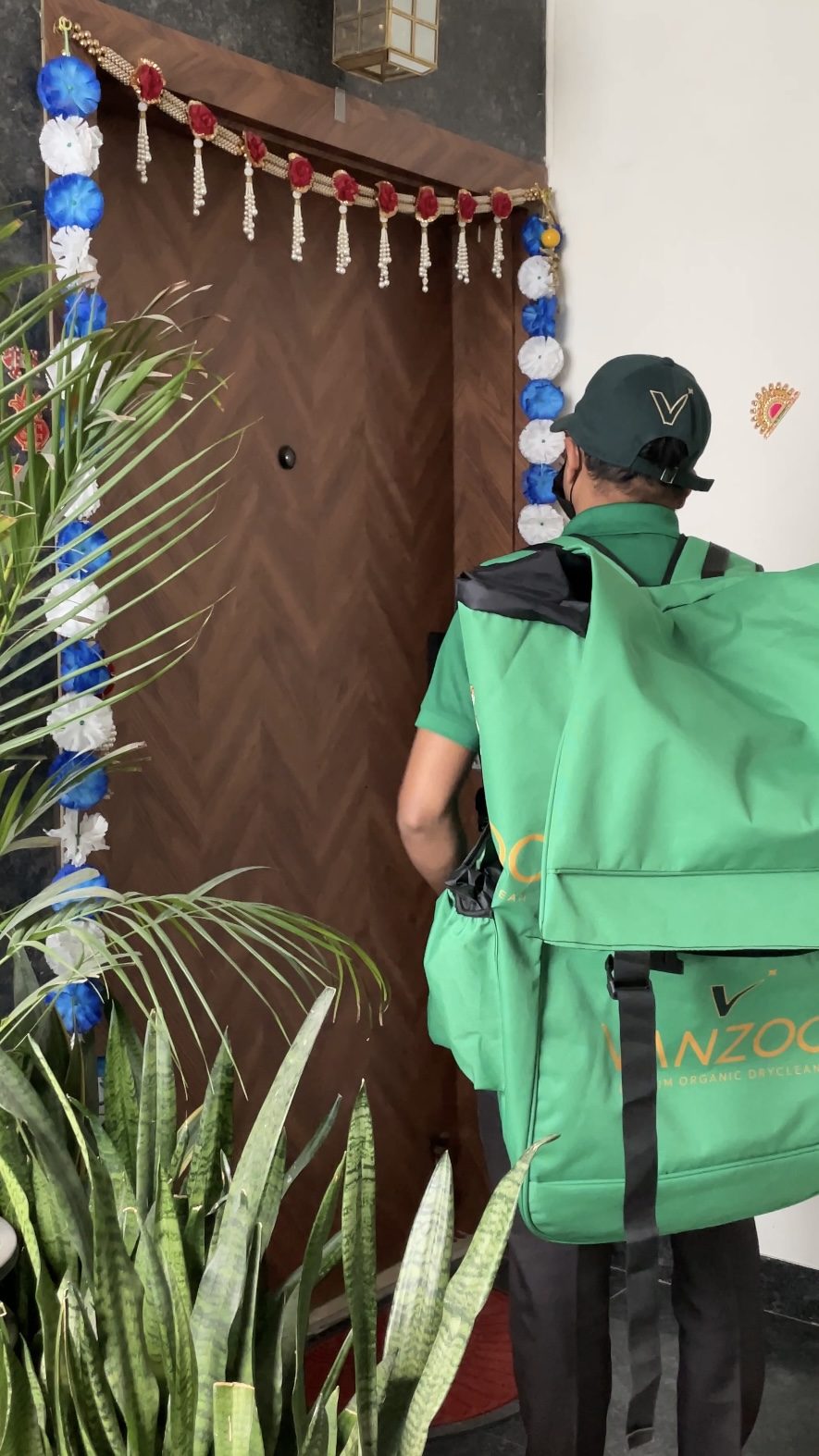 Vanzoo valet with a green delivery bag delivering at a doorstep