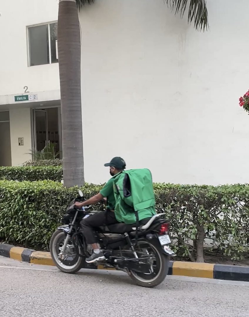 Vanzoo rider with a green delivery bag on a motorbike