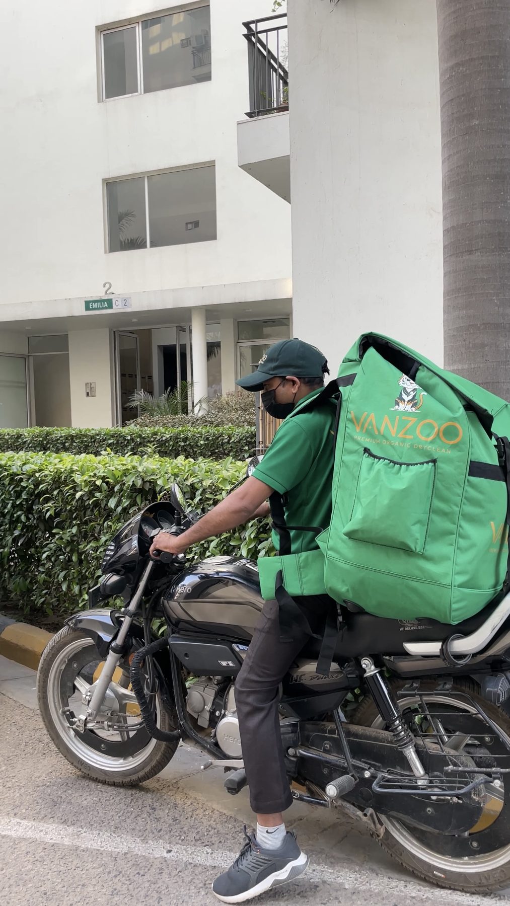 Vanzoo rider with a green delivery bag on a motorbike, ready for doorstep pickup and delivery