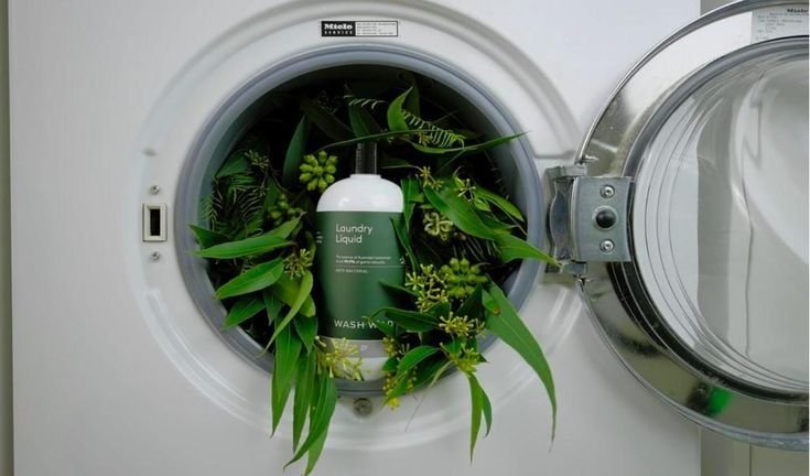 A basket of freshly washed clothes with eco-friendly laundry detergents, soap nuts, baking soda, and essential oils on a clean kitchen counter, highlighting natural and safe laundry solutions for sensitive skin, with sunlight streaming in for a fresh, eco-conscious home laundry concept.